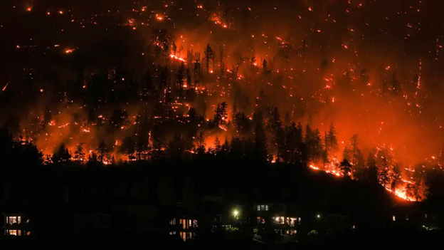 McDougall Creek wildfire burns on the mountainside above houses