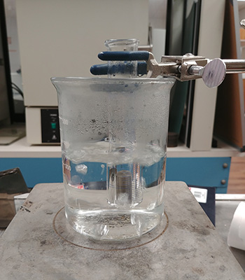 Beaker on a hot plate with a test tube containing the sample submerged in boiling water